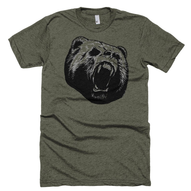May include: A green t-shirt with a black and white graphic of a bear's head with its mouth open.