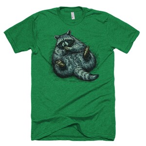 May include: A green t-shirt with a graphic of a raccoon curled up in a ball. The raccoon is drawn in a realistic style with detailed fur and a black mask.