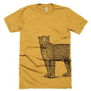 May include: A mustard yellow t-shirt with a black and white illustration of a leopard on the right side of the shirt.