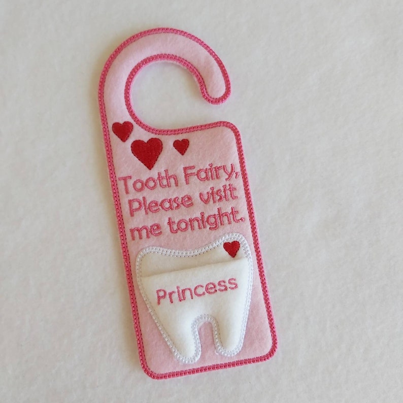 May include: Pink felt tooth fairy door hanger with a white felt tooth pocket and the text "Tooth Fairy, Please visit me tonight. Princess".