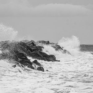 Fotodruck von Meereswellen, die auf Felsen im Mittelmeer in Frankreich brechen, schwarz-weiß