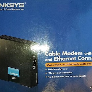 May include: A black Linksys cable modem with USB and Ethernet connections. The box features the text "Cable Modem with USB and Ethernet Connections" and "Own simple and affordable cable Internet connectivity".