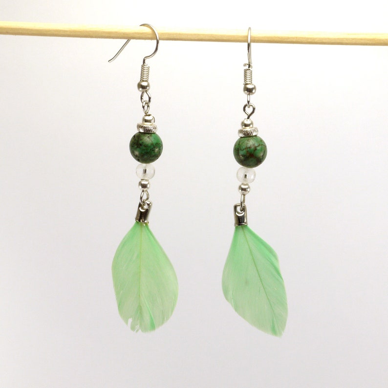 silver metal and pale green feather. Turquoise pearl earrings and transparent glass beads