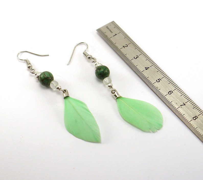 silver metal and pale green feather. Turquoise pearl earrings and transparent glass beads
