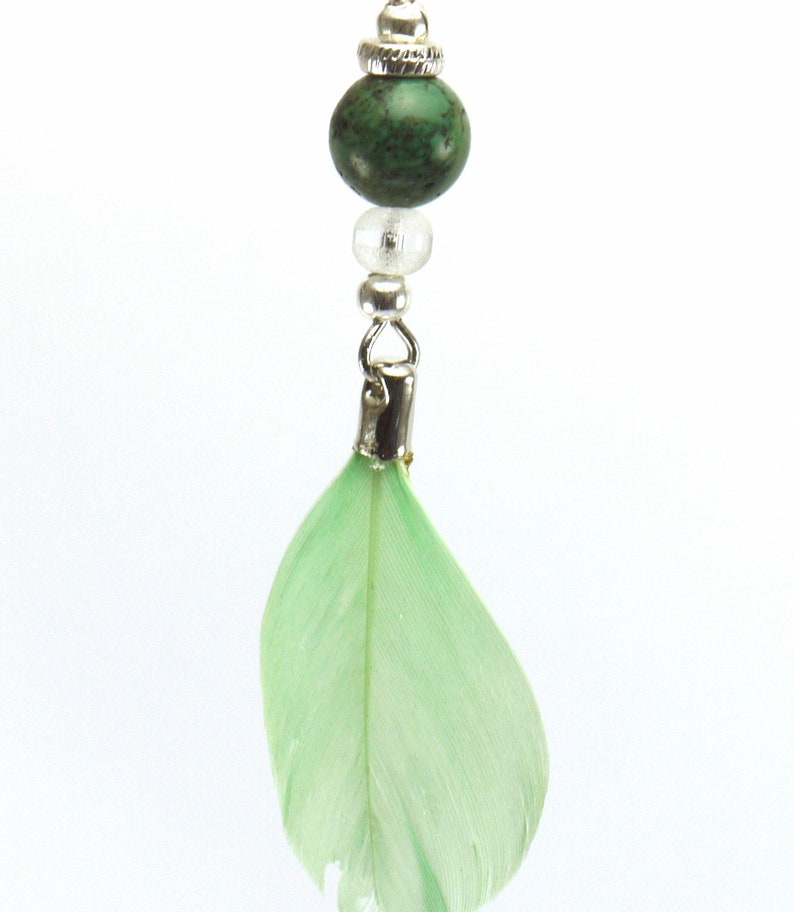 silver metal and pale green feather. Turquoise pearl earrings and transparent glass beads