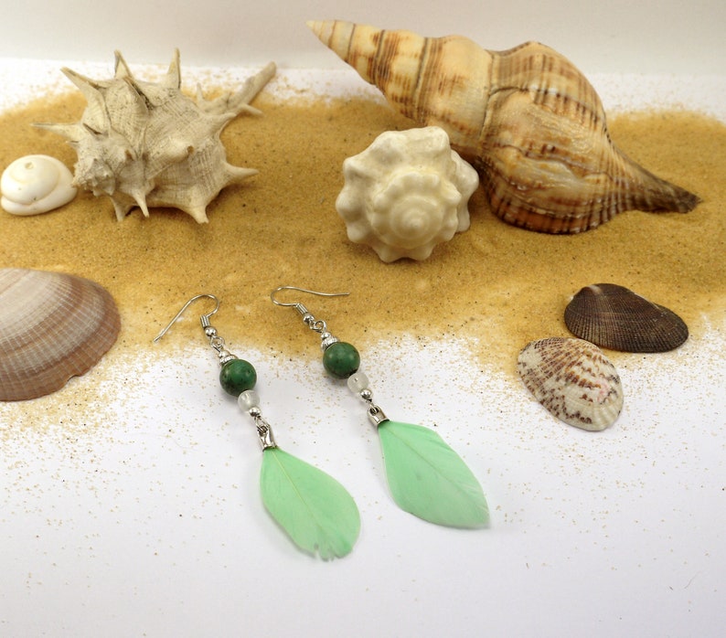 silver metal and pale green feather. Turquoise pearl earrings and transparent glass beads