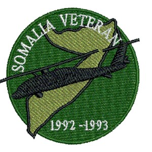 May include: A green circular patch with a black helicopter flying over a tan outline of Somalia. The text "SOMALIA VETERAN 1992-1993" is written in white around the edge of the patch.