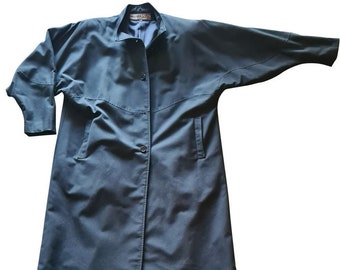 May include: A long, dark blue coat with a button closure and two pockets. The coat has a collar and long sleeves.