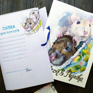 May include: A white folder with blue ribbon and the text "ПАПКА для паперів" in black. The folder has a watercolor illustration of two rats with the text "Saffron & Paprika" in black. A business card with the text "MoonHand Art" is in the bottom right corner.