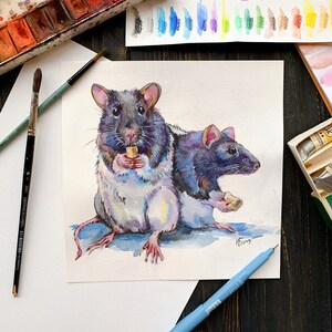 May include: Watercolor painting of two rats, one white with black spots and one black with purple hues, holding small pieces of food. The rats are painted in a realistic style with detailed fur and whiskers.
