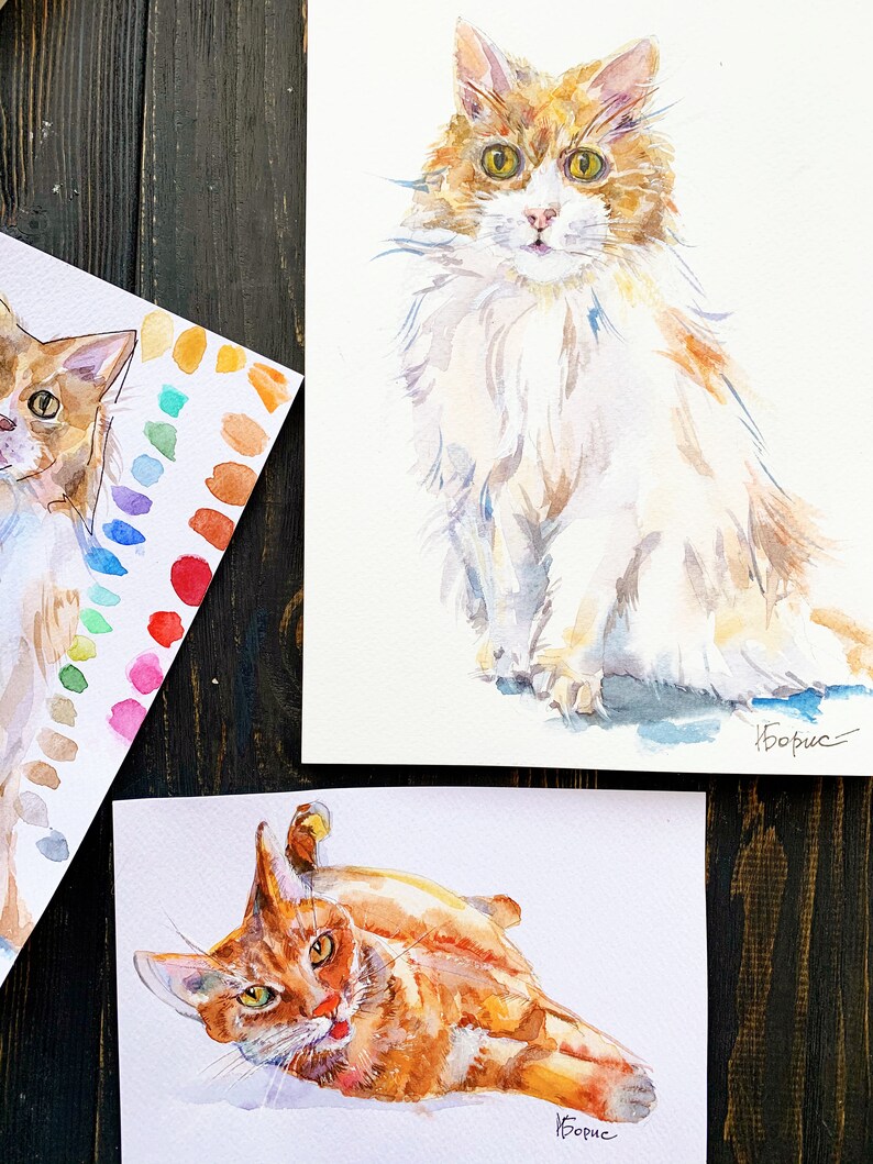 May include: Two watercolor paintings of orange tabby cats. The first painting shows a cat sitting with its head tilted to the side. The second painting shows a cat lying on its side with its paws in the air. Both paintings are signed "Boris".
