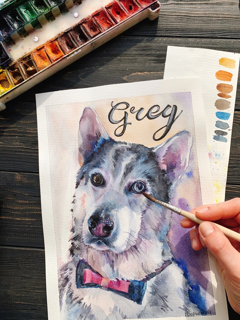 May include: Watercolor painting of a dog named Grey wearing a pink bow tie. The painting is on a white sheet of paper and is being worked on by an artist.