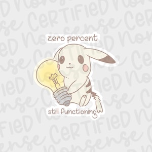 May include: A sticker featuring a cartoon Pikachu character holding a lightbulb. The text on the sticker reads "zero percent" above the character and "still functioning" below.