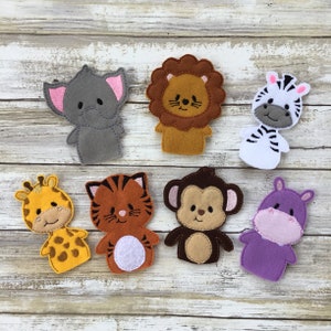 May include: A collection of seven felt animal finger puppets. The puppets include an elephant, lion, zebra, giraffe, tiger, monkey, and hippo. Each puppet is a different color and has embroidered details.