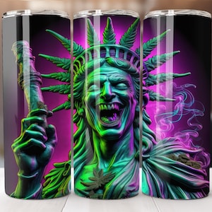 Può includere: Un bicchiere in acciaio inossidabile con una grafica colorata della Statua della Libertà con foglie di marijuana e fumo. La Statua della Libertà è raffigurata in uno schema di colori verde e viola con un ampio sorriso pieno di denti.