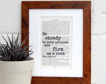 May include: A framed print of a book page with a quote from Mary Shelley's "Frankenstein". The quote reads "Be steady to your purpose and firm as a rock".