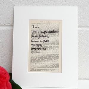 May include: A black and white print of a page from the book Great Expectations by Charles Dickens. The text on the page reads "I have great expectations for the future, because the past was highly overrated."