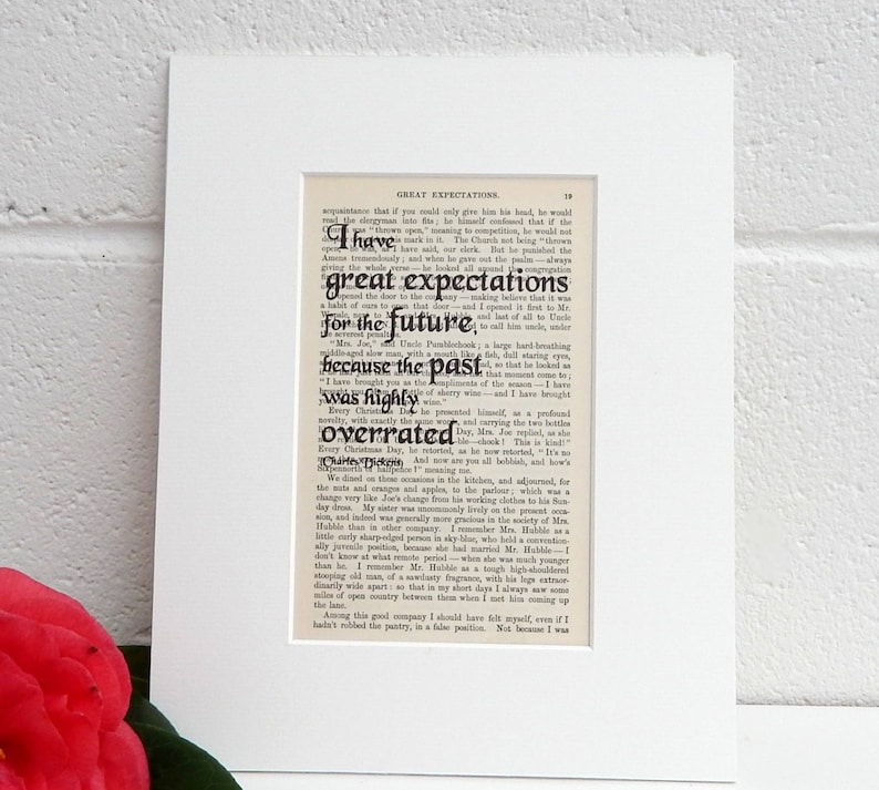May include: A black and white print of a page from the book Great Expectations by Charles Dickens. The text on the page reads "I have great expectations for the future, because the past was highly overrated."