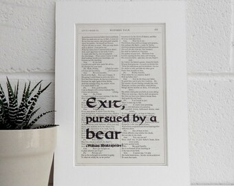 May include: A black and white framed print of a page from a book. The text is from William Shakespeare's Winter's Tale. The text is highlighted with the words "Exit, pursued by a bear" in bold black font.