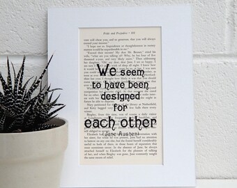 May include: A close-up of a book page with the text "We seem to have been designed for each other" highlighted in black. The text is from the novel Pride and Prejudice by Jane Austen.
