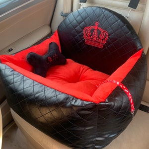 Exclusive car seat for dogs black with red soft plush. Decorated with a crown and personalized. Kit for safe driving with a dog.