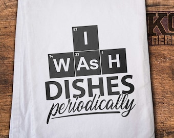 May include: White kitchen towel with the text "I Wash Dishes periodically" written in black. The text is styled to look like a periodic table with the letters "W", "As", and "H" representing the elements.