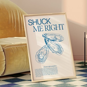 May include: A framed print with the text "SHUCK ME RIGHT" in blue lettering. The print features a line drawing of three oysters in blue on a white background. The text "shuck it right everytime" is below the oysters.