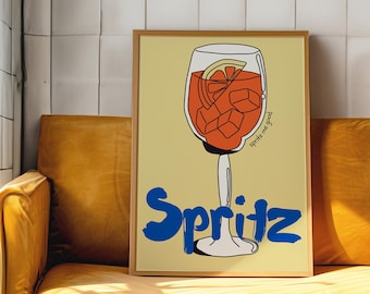 May include: A framed illustration of a glass of Spritz with ice cubes and a lemon slice. The text "Spritz me good" is written on the side of the glass. The word "Spritz" is written in large blue letters at the bottom of the illustration.