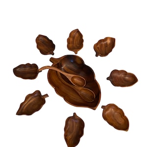 May include: A wooden salad bowl set with a large leaf-shaped bowl and seven smaller leaf-shaped bowls. The set includes a wooden serving spoon.