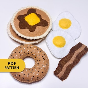 May include: Felt breakfast food play set with a bagel, two fried eggs, a stack of pancakes, and a strip of bacon.  The set is perfect for pretend play and imaginative fun.