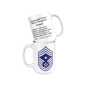 May include: Two white ceramic mugs stacked vertically. The top mug features black text reading: Command Chief Master Sergeant /noun/ someone who does precision guesswork based on unreliable data provided by those of questionable knowledge see also: wizard, magician. The bottom mug displays a blue military rank insignia featuring chevrons and stars.