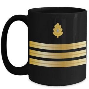 May include: Black ceramic coffee mug with a gold oak leaf and four gold stripes.