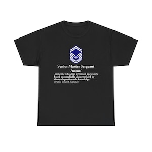 May include: Black t-shirt with a white graphic. The graphic includes a blue and white emblem and text that reads "Senior Master Sergeant /noun/ -someone who does precision guesswork based on unreliable data provided by those of questionable knowledge see also: wizard, magician."
