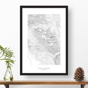 May include: A black and white topographic map print of Mount Timpanogos, Utah. The print shows the elevation contours of the mountain. The title "Mount Timpanogos" is printed at the bottom of the print.