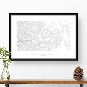 May include: A black and white topographic map print of Park City, Alta, Snowbird, and Deer Valley, Utah. The print shows the elevation contours of the mountains in the area.
