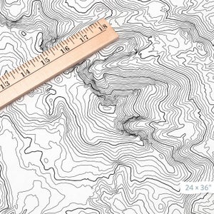 K&ouml;nnte beinhalten: Ein Schwarzwei&szlig;-Druck einer topografischen Karte mit einem Lineal darauf. Der Druck zeigt eine Reihe von H&ouml;henlinien, die eine visuelle Darstellung eines Gebirges erzeugen. Der Druck misst 61 cm mal 91 cm.