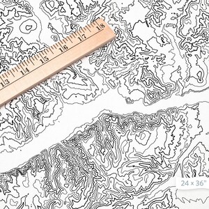 May include: A black and white topographic map print with a ruler on top. The map shows a mountainous region with contour lines. The print measures 24 x 36 inches.
