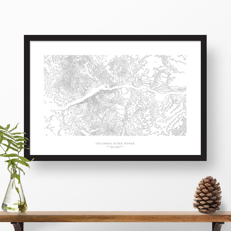 May include: A black and white line art print of the Columbia River Gorge. The print features detailed contour lines depicting the topography of the area. The text "COLUMBIA RIVER GORGE" is printed at the bottom of the print.