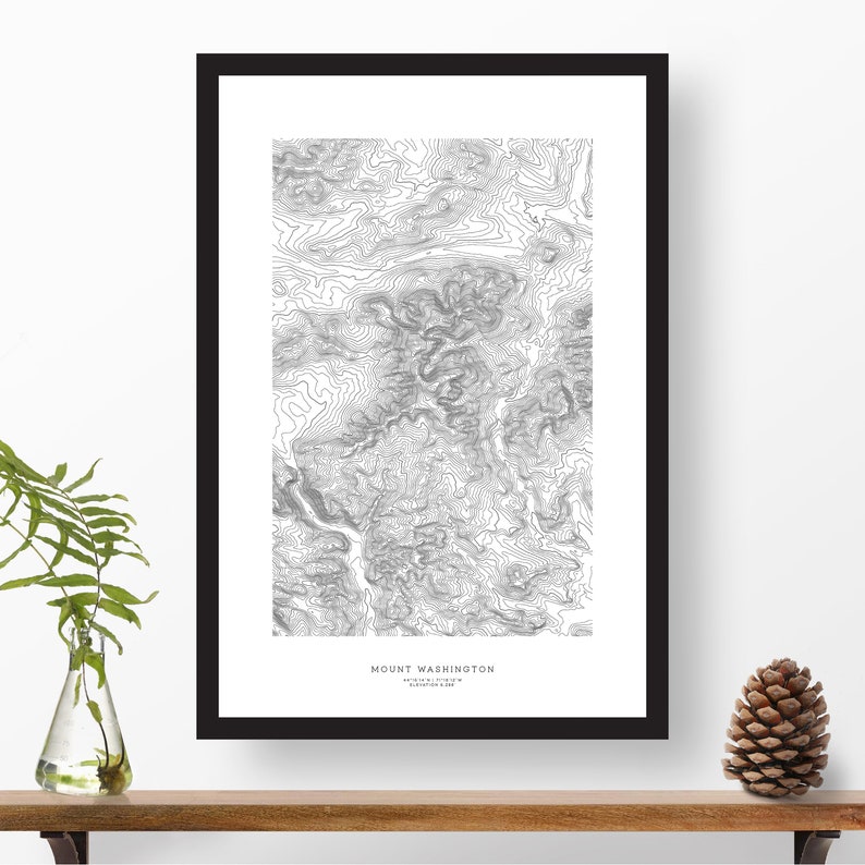 Pu&ograve; includere: Una stampa di mappa topografica in bianco e nero del Monte Washington, nel New Hampshire, con il nome della montagna e la sua altitudine stampati in basso sulla stampa. La stampa &egrave; incorniciata in una cornice nera.