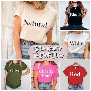 May include: A collage of Bella Canvas t-shirts in various colors, including natural, black, white, olive, charity pink, and red. Each shirt is displayed on a person, with the color name printed on the front.