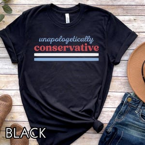 May include: Black t-shirt with the words "unapologetically conservative" in blue and red, with a blue and white stripe design. The word "BLACK" is printed at the bottom of the shirt.