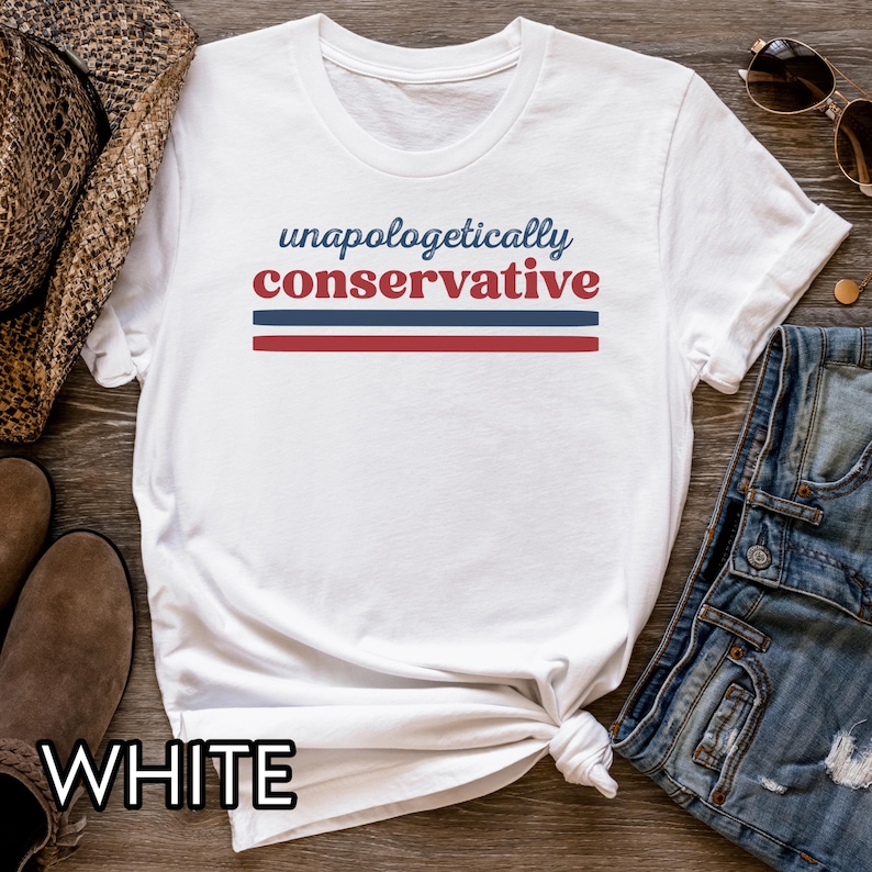 May include: White t-shirt with the text "unapologetically conservative" in blue and red. The text is above two horizontal stripes, one blue and one red. The word "WHITE" is printed at the bottom of the shirt.