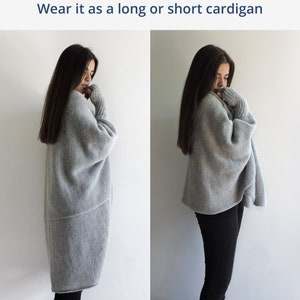 Puede incluir: Un cárdigan de punto gris que se puede llevar como cárdigan largo o corto. El cárdigan tiene un corte holgado y se muestra con pantalones negros.