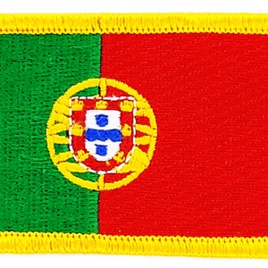 Könnte beinhalten: Ein grüner und roter gestickter Aufnäher mit gelbem Rand. Der Aufnäher zeigt das Wappen Portugals, ein Schild mit einem blauen und weißen Kreuz in einem Kreis.