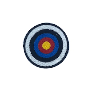 Può includere: Un cerotto ricamato a forma di bersaglio con cerchi bianchi, neri, blu, rossi e gialli.