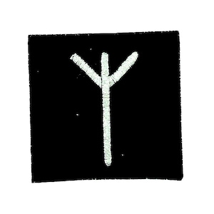 May include: Black square patch featuring a white embroidered rune symbol. The rune is a vertical line with three branches at the top. The patch has a textured appearance.