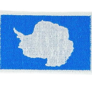 May include: A blue embroidered patch with a white outline. The patch features a white silhouette of the continent of Antarctica.