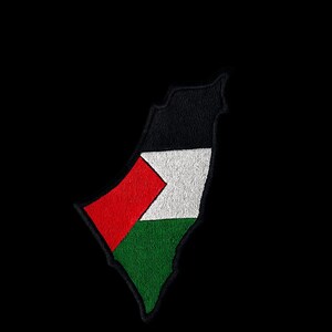 Pode incluir: Remendo bordado em forma da Palestina, com as cores da bandeira palestina: preto, branco, vermelho e verde. O remendo está sobre um fundo preto.
