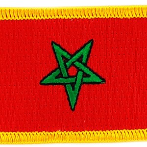 Op de afbeelding: Een rood geborduurd patch met een groene vijfpuntige ster in het midden. De ster is geel omrand en de hele patch heeft een gele rand.
