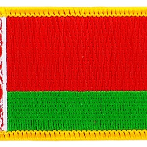 May include: A red and green embroidered patch with a white design on the left side, surrounded by a yellow border.